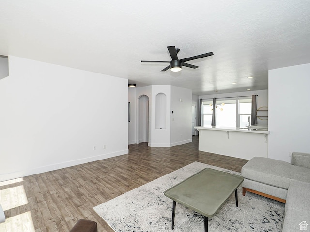 1792 W Dalmeny Way, Riverton, UT 84065 - living area with wood finished floors, ceiling fan, and arched walkways