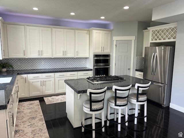 10337 S Wapati Moon Pl, South Jordan, UT 84095 - kitchen with appliances with stainless steel finishes, recessed lighting, a kitchen island, white cabinetry, and decorative backsplash