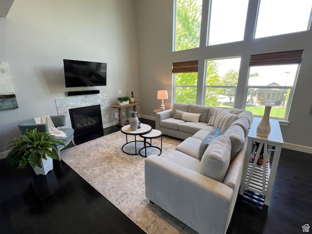 10337 S Wapati Moon Pl, South Jordan, UT 84095 - living area featuring a glass covered fireplace, a high ceiling, and wood finished floors