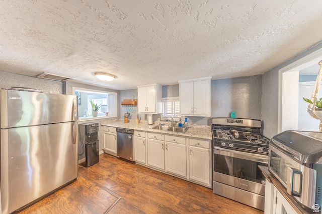 525 3rd St, Ogden, UT 84404 - kitchen with stainless steel appliances, dark wood-type flooring, a textured ceiling, and white cabinetry