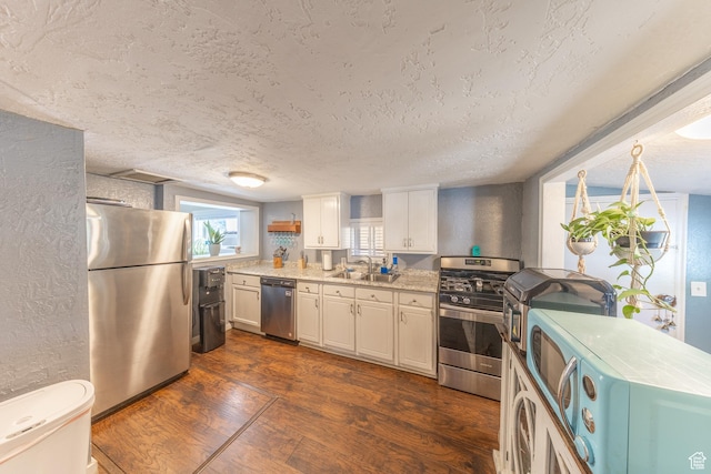 525 3rd St, Ogden, UT 84404 - kitchen featuring appliances with stainless steel finishes, dark wood-style floors, a textured ceiling, and white cabinets