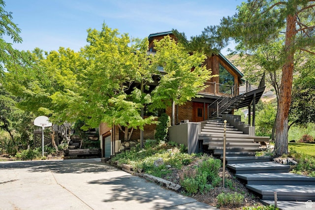 4307 Churchill Dr N Unit 97, Provo, UT 84604 - view of front of property with stairs, concrete driveway, a deck, brick siding, and a garage