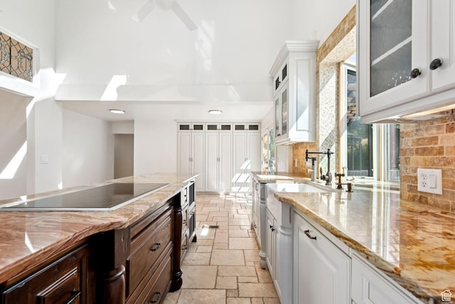 4307 Churchill Dr N Unit 97, Provo, UT 84604 - kitchen with black electric cooktop, stone tile floors, a towering ceiling, white cabinets, and light stone countertops