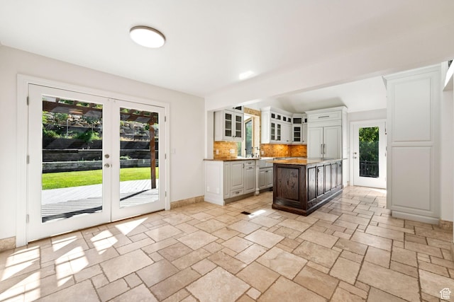4307 Churchill Dr N Unit 97, Provo, UT 84604 - kitchen with tasteful backsplash, stone tile flooring, french doors, and glass insert cabinets