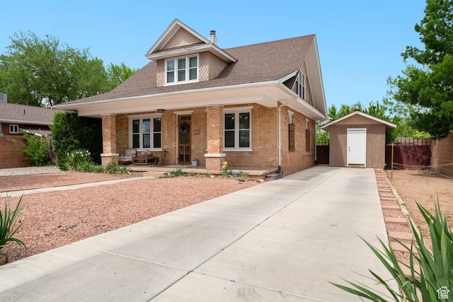 266 W 200 S, Hurricane, UT 84737 - view of front of property with covered porch, brick siding, a storage shed, concrete driveway, and roof with shingles