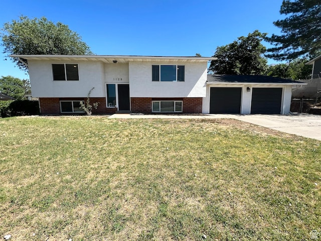 1128 W 600 N, Orem, UT 84057 - bi-level home with stucco siding, driveway, an attached garage, a front yard, and brick siding