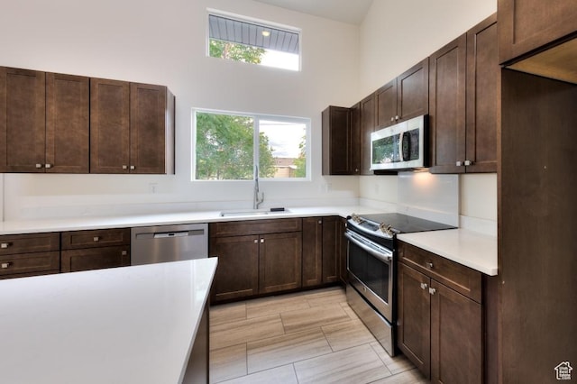 1191 Wagner Ave, Moab, UT 84532 - kitchen with stainless steel appliances, light countertops, a towering ceiling, and dark brown cabinets
