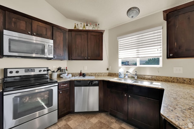 8264 S Resaca Dr Unit K9, Sandy, UT 84070 - kitchen featuring appliances with stainless steel finishes, dark brown cabinets, stone finish flooring, and light stone countertops
