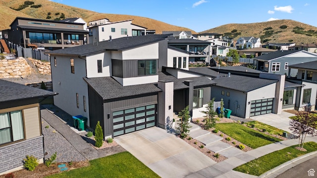 5488 N Valley Rd E, Lehi, UT 84043 - contemporary home featuring concrete driveway, a mountain view, a residential view, roof with shingles, and stucco siding