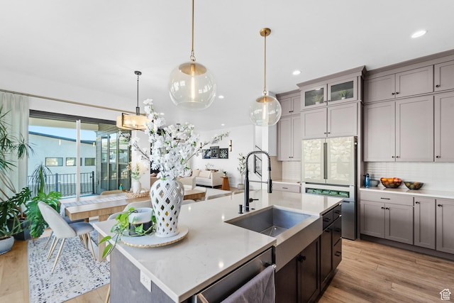 5488 N Valley Rd E, Lehi, UT 84043 - kitchen with backsplash, stainless steel dishwasher, light wood-style floors, an island with sink, and recessed lighting