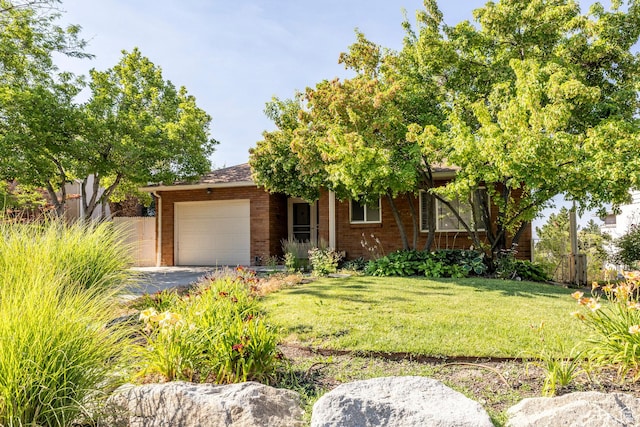 420 E 12th Ave, Salt Lake City, UT 84103 - view of front of house featuring an attached garage, brick siding, a front yard, and driveway