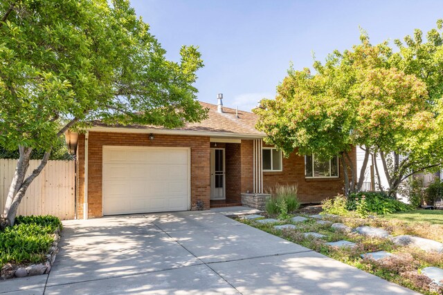 420 E 12th Ave, Salt Lake City, UT 84103 - ranch-style house with an attached garage, brick siding, concrete driveway, and a shingled roof