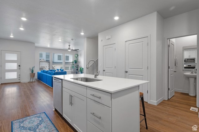 937 W Terracotta Dr, Saratoga Springs, UT 84045 - kitchen featuring stainless steel appliances, dark wood finished floors, white cabinetry, a breakfast bar area, and recessed lighting