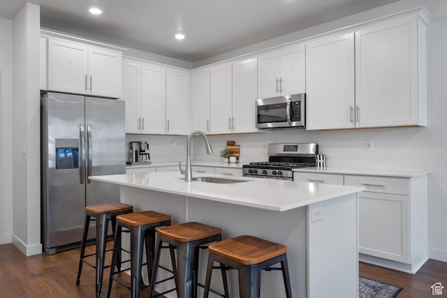 937 W Terracotta Dr, Saratoga Springs, UT 84045 - kitchen featuring appliances with stainless steel finishes, dark wood finished floors, recessed lighting, a kitchen breakfast bar, and white cabinetry