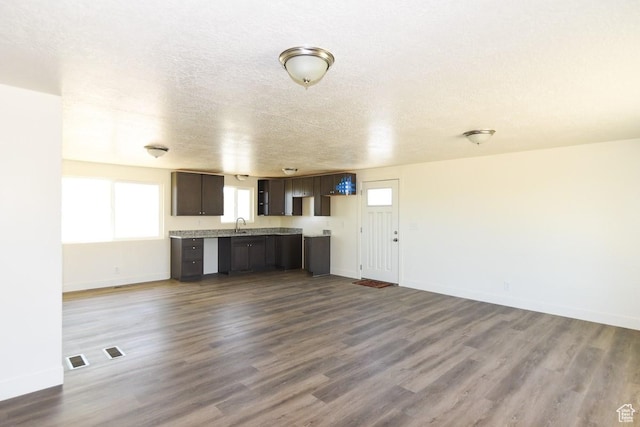 327 N 600 W, Grantsville, UT 84029 - unfurnished living room with dark wood-style flooring, plenty of natural light, and a textured ceiling