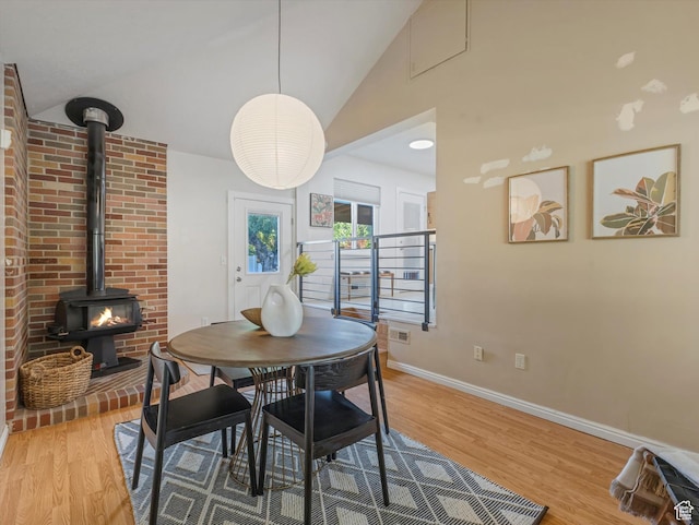 1406 W Talisman Dr, Salt Lake City, UT 84116 - dining area featuring light wood finished floors, a wood stove, and vaulted ceiling