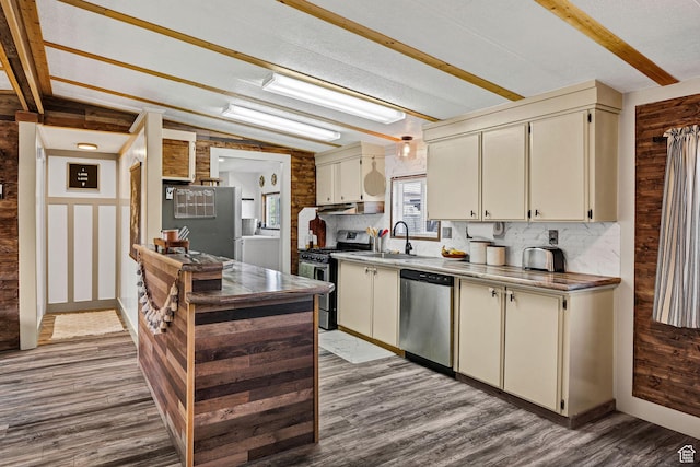 20105 N 5000 W, Plymouth, UT 84330 - kitchen featuring stainless steel appliances, cream cabinetry, wood finished floors, tasteful backsplash, and under cabinet range hood