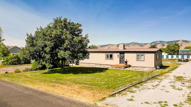 20105 N 5000 W, Plymouth, UT 84330 - manufactured / mobile home featuring a mountain view and a front lawn
