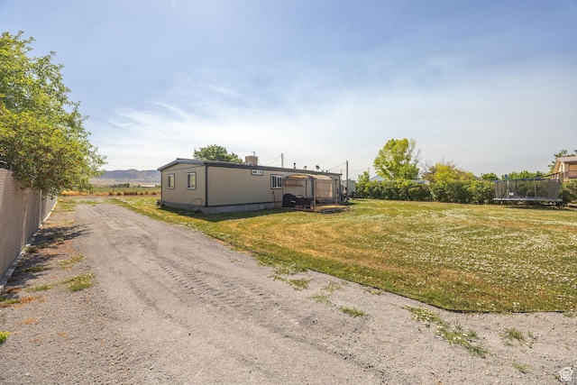 20105 N 5000 W, Plymouth, UT 84330 - back of house featuring a trampoline and a yard