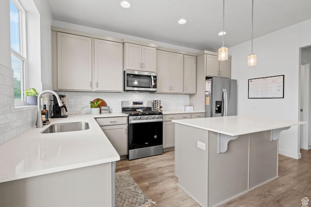 1162 W 1100 S, Clearfield, UT 84015 - kitchen with appliances with stainless steel finishes, decorative backsplash, a kitchen island, a breakfast bar, and recessed lighting