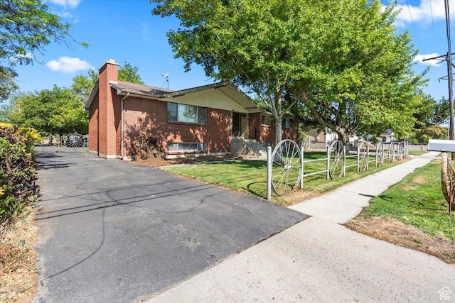 7738 S 2700 W, West Jordan, UT 84084 - view of front of home with a chimney, brick siding, a front lawn, and driveway