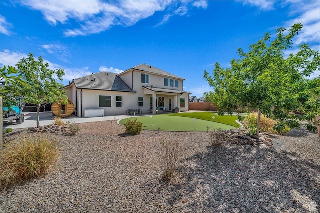 2249 E Fieldstone Cir, St George, UT 84790 - back of house featuring an area to practice putting, a patio, stucco siding, and a fenced backyard
