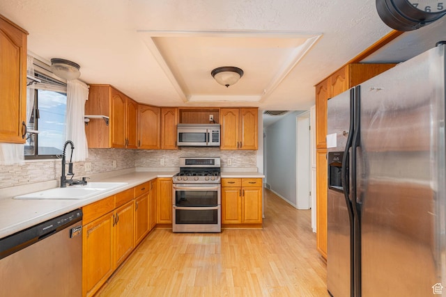 564 S 940 W, Cedar City, UT 84720 - kitchen with stainless steel appliances, a raised ceiling, light wood-style floors, decorative backsplash, and light countertops