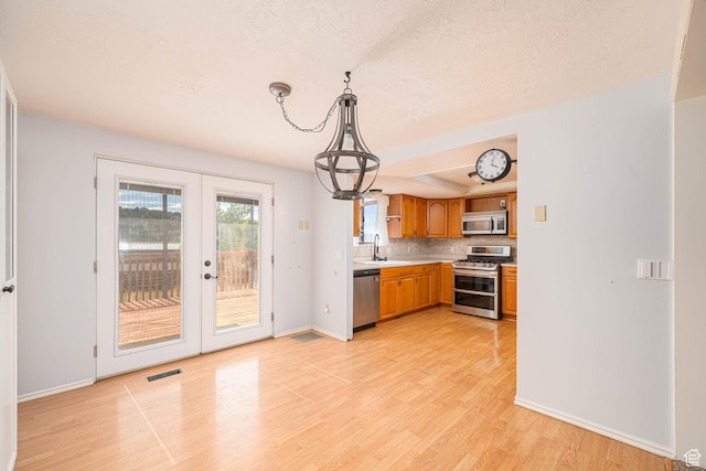 564 S 940 W, Cedar City, UT 84720 - kitchen with appliances with stainless steel finishes, french doors, light countertops, light wood-type flooring, and backsplash
