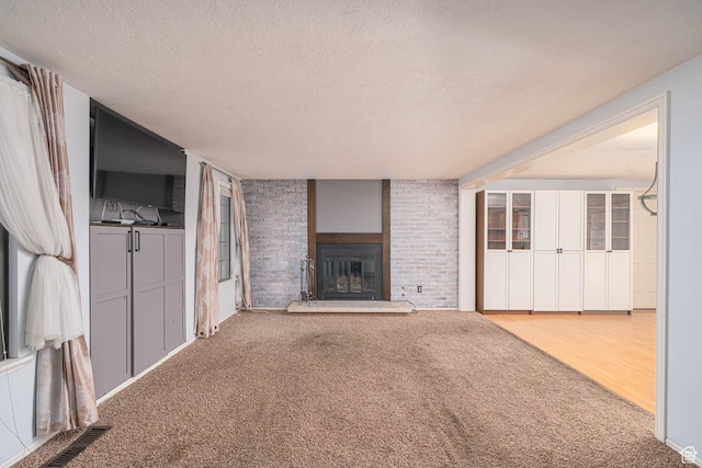 564 S 940 W, Cedar City, UT 84720 - unfurnished living room with a brick fireplace, a textured ceiling, and carpet