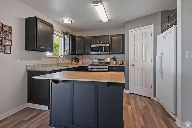 7526 S Park Maple Dr, West Jordan, UT 84081 - kitchen with appliances with stainless steel finishes, dark wood finished floors, a kitchen island, and dark brown cabinets