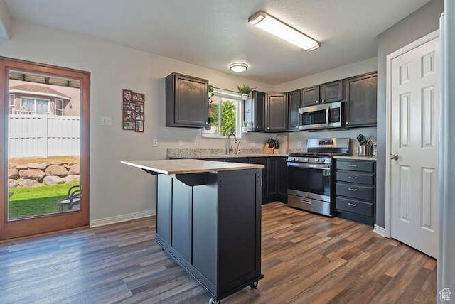 7526 S Park Maple Dr, West Jordan, UT 84081 - kitchen with stainless steel appliances, light countertops, dark wood-type flooring, and a breakfast bar area