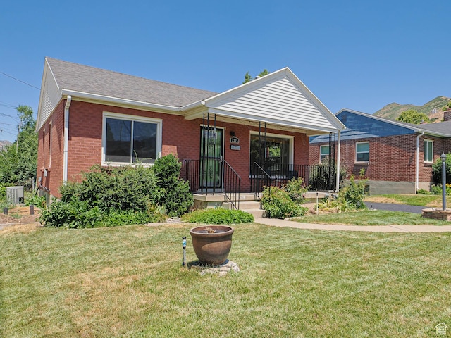 2375 E Redondo Ave, Salt Lake City, UT 84108 - view of front facade featuring brick siding, a front yard, a shingled roof, and covered porch