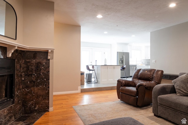 11089 S Justin Dr, Sandy, UT 84092 - living room featuring light wood finished floors, recessed lighting, and a fireplace with flush hearth