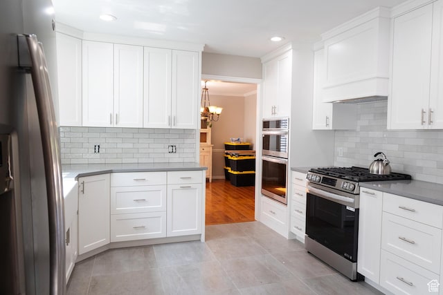 11089 S Justin Dr, Sandy, UT 84092 - kitchen with stainless steel appliances, a chandelier, decorative backsplash, white cabinets, and recessed lighting