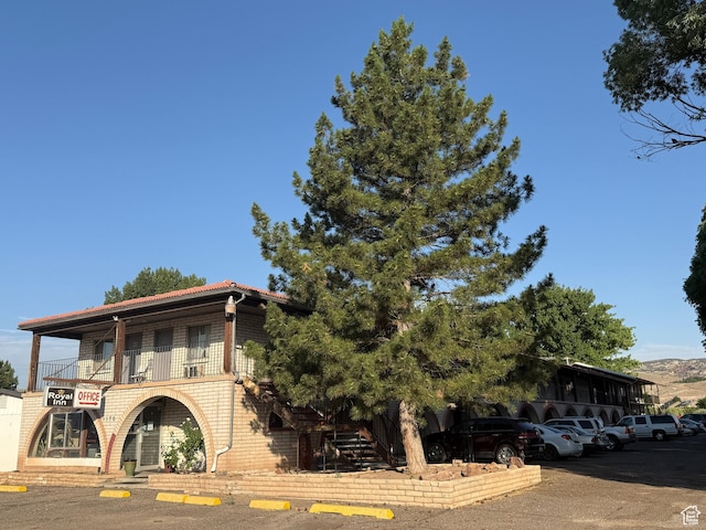 1170 S Cove View Rd, Richfield, UT 84701 - view of front of house with uncovered parking, a balcony, brick siding, and a tile roof