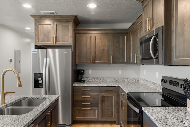 130 W Seasons Loop Upper, Upper, Garden City, UT 84028 - kitchen featuring appliances with stainless steel finishes, electric panel, light stone countertops, recessed lighting, and dark brown cabinets