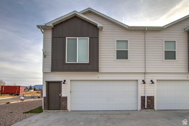 130 W Seasons Loop Upper, Upper, Garden City, UT 84028 - view of front facade with board and batten siding, stone siding, and concrete driveway