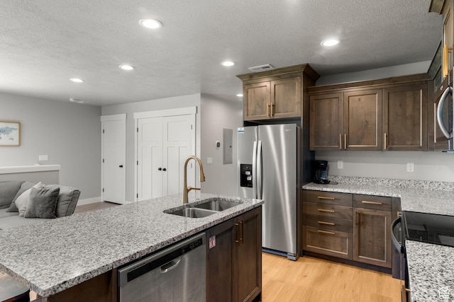 130 W Seasons Loop Upper, Upper, Garden City, UT 84028 - kitchen featuring stainless steel appliances, recessed lighting, a center island with sink, a textured ceiling, and light wood-style floors