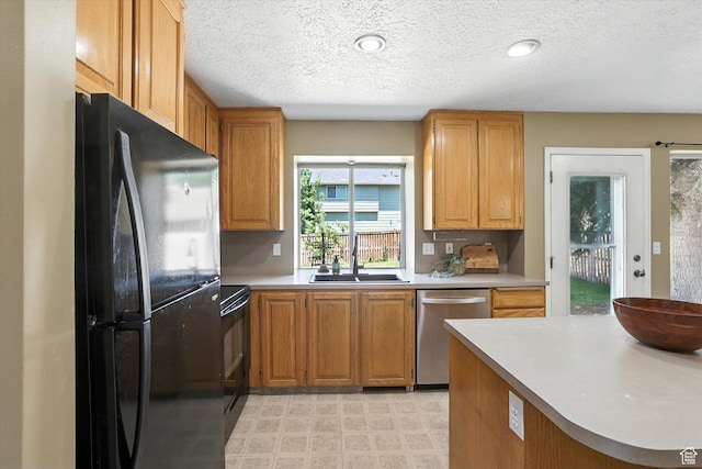 1298 Eastridge Cir, Logan, UT 84321 - kitchen with black appliances, light countertops, a textured ceiling, brown cabinetry, and light flooring