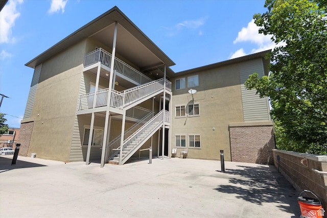 75 E 200 N Unit 206, Provo, UT 84606 - rear view of property with stucco siding, brick siding, stairs, and a balcony