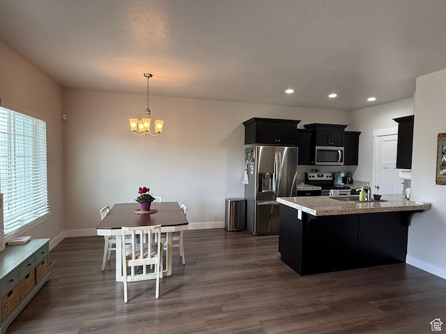 7579 N Cottage Ln, Eagle Mountain, UT 84005 - kitchen with appliances with stainless steel finishes, dark cabinetry, a chandelier, recessed lighting, and dark wood-style flooring