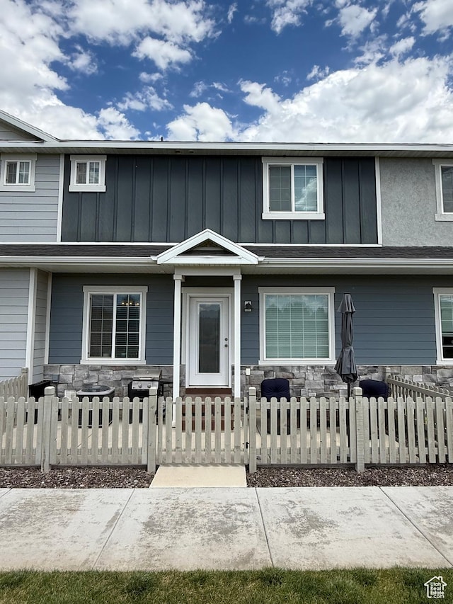 7579 N Cottage Ln, Eagle Mountain, UT 84005 - traditional-style house with stone siding, board and batten siding, a fenced front yard, and a gate