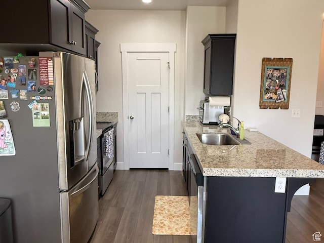 7579 N Cottage Ln, Eagle Mountain, UT 84005 - kitchen with appliances with stainless steel finishes, dark wood-style floors, a peninsula, a kitchen bar, and recessed lighting