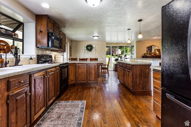 453 Sheridan Cir, Centerville, UT 84014 - kitchen with black appliances, light countertops, a textured ceiling, dark wood finished floors, and decorative light fixtures