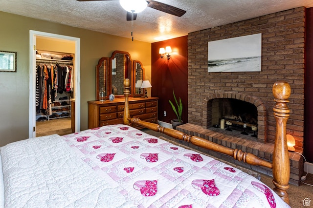 453 Sheridan Cir, Centerville, UT 84014 - bedroom featuring a walk in closet, carpet, a textured ceiling, a fireplace, and ceiling fan