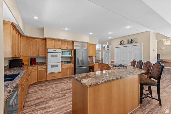 13032 S 1300 W, Riverton, UT 84065 - kitchen featuring stainless steel appliances, light wood-style flooring, a breakfast bar area, stone counters, and recessed lighting