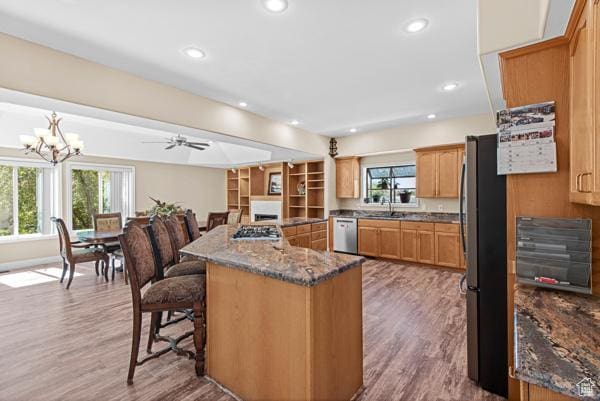 13032 S 1300 W, Riverton, UT 84065 - kitchen with stainless steel appliances, a kitchen bar, wood finished floors, dark stone counters, and a center island