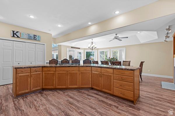 13032 S 1300 W, Riverton, UT 84065 - kitchen with wood finished floors, a chandelier, brown cabinetry, a ceiling fan, and recessed lighting