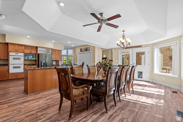 13032 S 1300 W, Riverton, UT 84065 - dining room featuring a raised ceiling, wood finished floors, a ceiling fan, a chandelier, and french doors