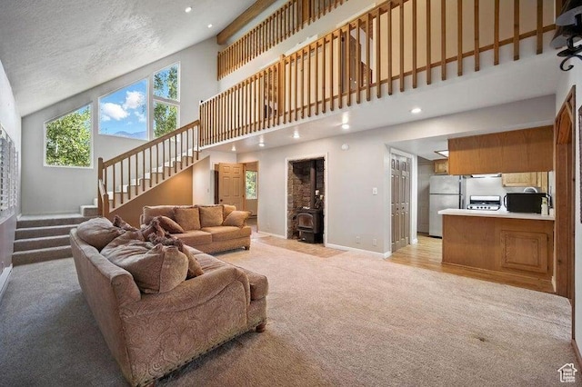 10 S 900 E, Pine Valley, UT 84781 - living room featuring light carpet, high vaulted ceiling, stairs, a wood stove, and recessed lighting